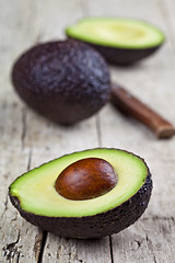 Image showing Fresh avocado and knife on old wooden table background. Fresh av