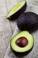 Image showing Organic avocado on linen napkin on rustic wooden table backgroun