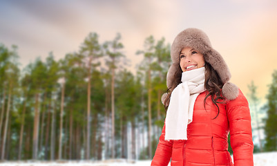 Image showing happy woman in fur hat over winter forest