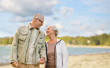 Image showing happy senior couple over beach background