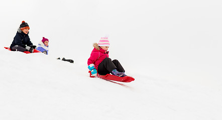 Image showing kids sliding on sleds down snow hill in winter