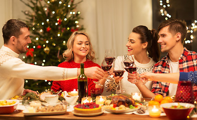 Image showing happy friends drinking red wine at christmas party