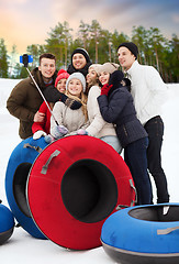 Image showing friends with snow tubes taking selfie in winter