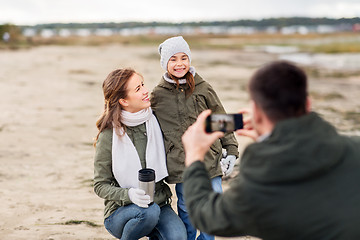 Image showing family photographing by smartphone on autumn beach