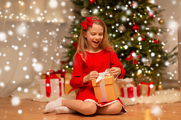 Image showing smiling girl with christmas gift at home