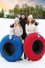 Image showing happy friends with snow tubes outdoors in winter