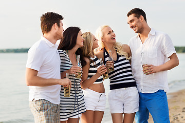 Image showing happy friends drinking non alcoholic beer on beach