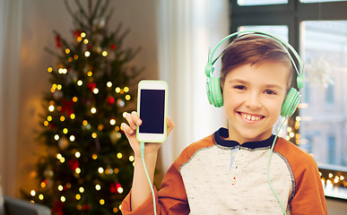 Image showing boy with smartphone and headphones on christmas