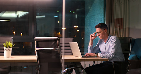 Image showing man working on laptop in dark office