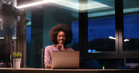 Image showing black businesswoman using a laptop in night startup office