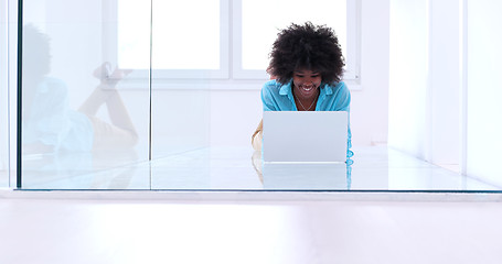 Image showing black women using laptop computer on the floor