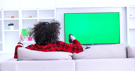 Image showing Young couple on the sofa watching television