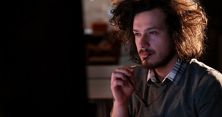 Image showing man working on computer in dark office