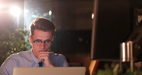 Image showing man working on computer in dark office