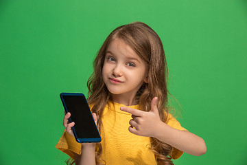 Image showing The happy teen girl standing and smiling against green background.