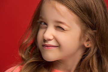 Image showing The happy teen girl standing and smiling against red background.