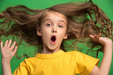 Image showing Beautiful teen girl looking suprised isolated on green