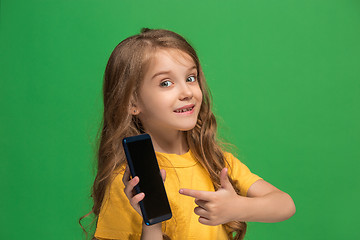 Image showing The happy teen girl standing and smiling against green background.