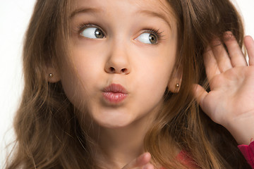 Image showing The young teen girl whispering a secret behind her hand over white background