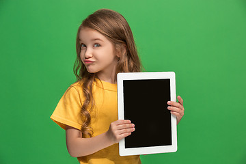 Image showing Little funny girl with tablet on green background