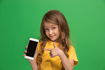 Image showing The happy teen girl standing and smiling against green background.