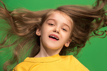 Image showing The happy teen girl standing and smiling against green background.