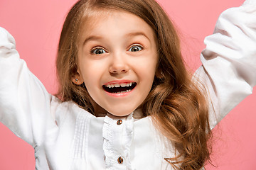 Image showing The happy teen girl standing and smiling against pink background.