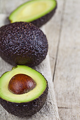 Image showing Organic avocado on linen napkin on rustic wooden table backgroun