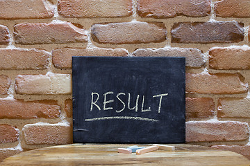 Image showing Chalk board with the word RESULT drown by hand on wooden table o