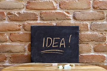 Image showing Black board with the word IDEA drown by hand on wooden table on 