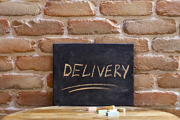 Image showing Chalk board with the word DELIVERY drown by hand on wooden table