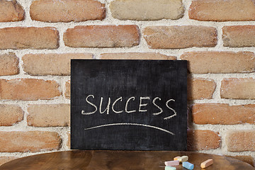 Image showing Chalk board with the word SUCCESS drown by hand on wooden table 