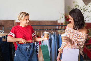 Image showing happy women with coffee at vintage clothing store