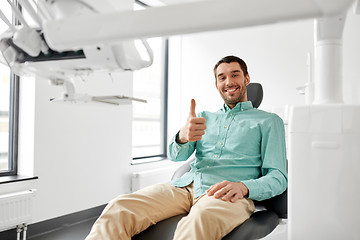 Image showing smiling patient showing thumbs up at dental clinic