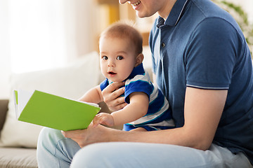 Image showing baby boy and father with book at home