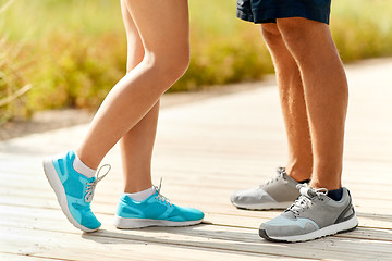 Image showing legs of couple of sportsmen in sneakers outdoors