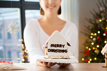 Image showing close up of woman with christmas gingerbread house