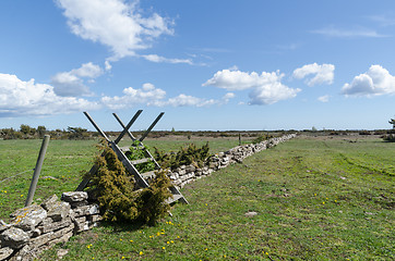 Image showing Wooden stile by a dry stone wall in spring season at the great p