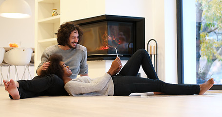 Image showing Young Couple using digital tablet on the floor