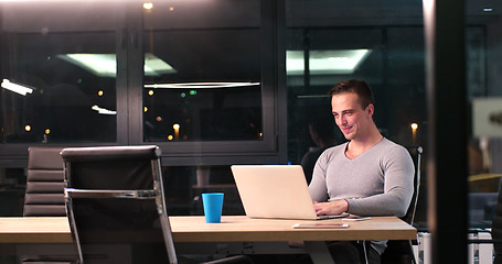 Image showing man working on laptop in dark office