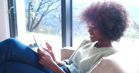 Image showing african american woman at home using digital tablet