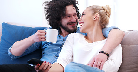 Image showing Young couple on the sofa watching television