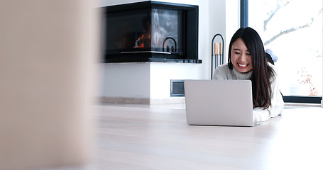 Image showing Asian woman using laptop on floor