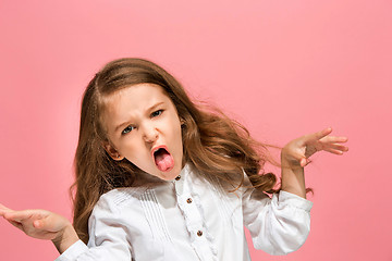 Image showing Portrait of angry teen girl on a pink studio background