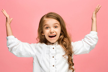 Image showing The happy teen girl standing and smiling against pink background.