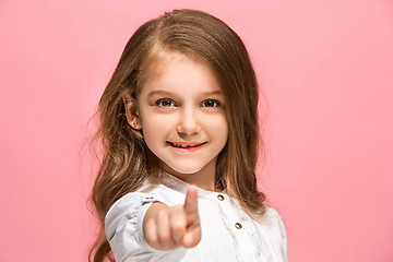 Image showing The happy teen girl standing and smiling against pink background.