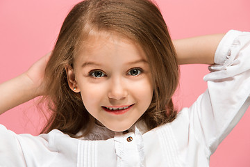 Image showing The happy teen girl standing and smiling against pink background.