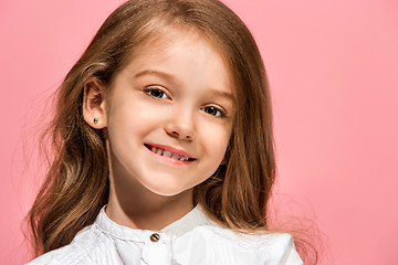 Image showing The happy teen girl standing and smiling against pink background.