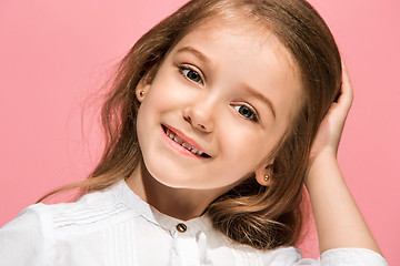 Image showing The happy teen girl standing and smiling against pink background.