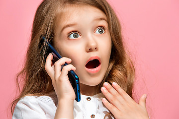 Image showing The happy teen girl standing and smiling against pink background.